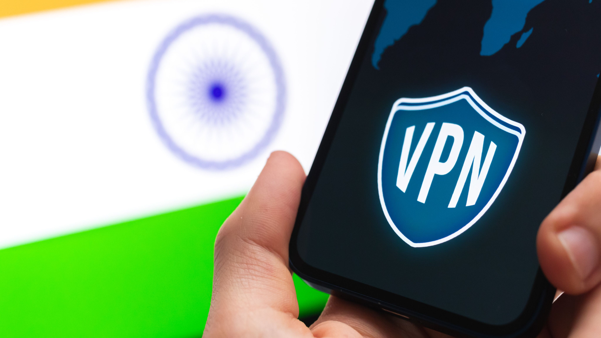 Hand holding smartphone with VPN logo on screen and Indian flag in background
