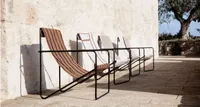 A row of deckchairs with black metal frames and abstract printed fabric