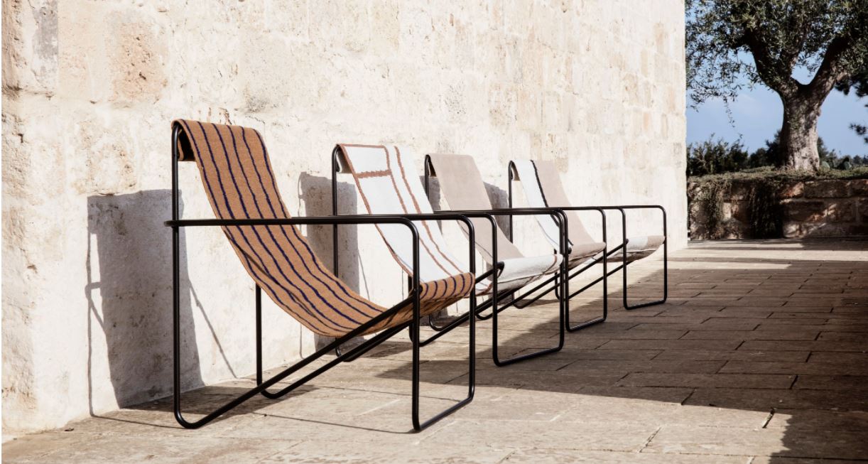A row of deckchairs with black metal frames and abstract printed fabric