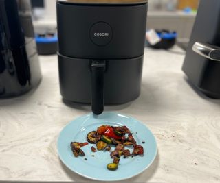 Frozen Mediterranean vegetables on a plate in front of the Cosori LE Pro Air Fryer.