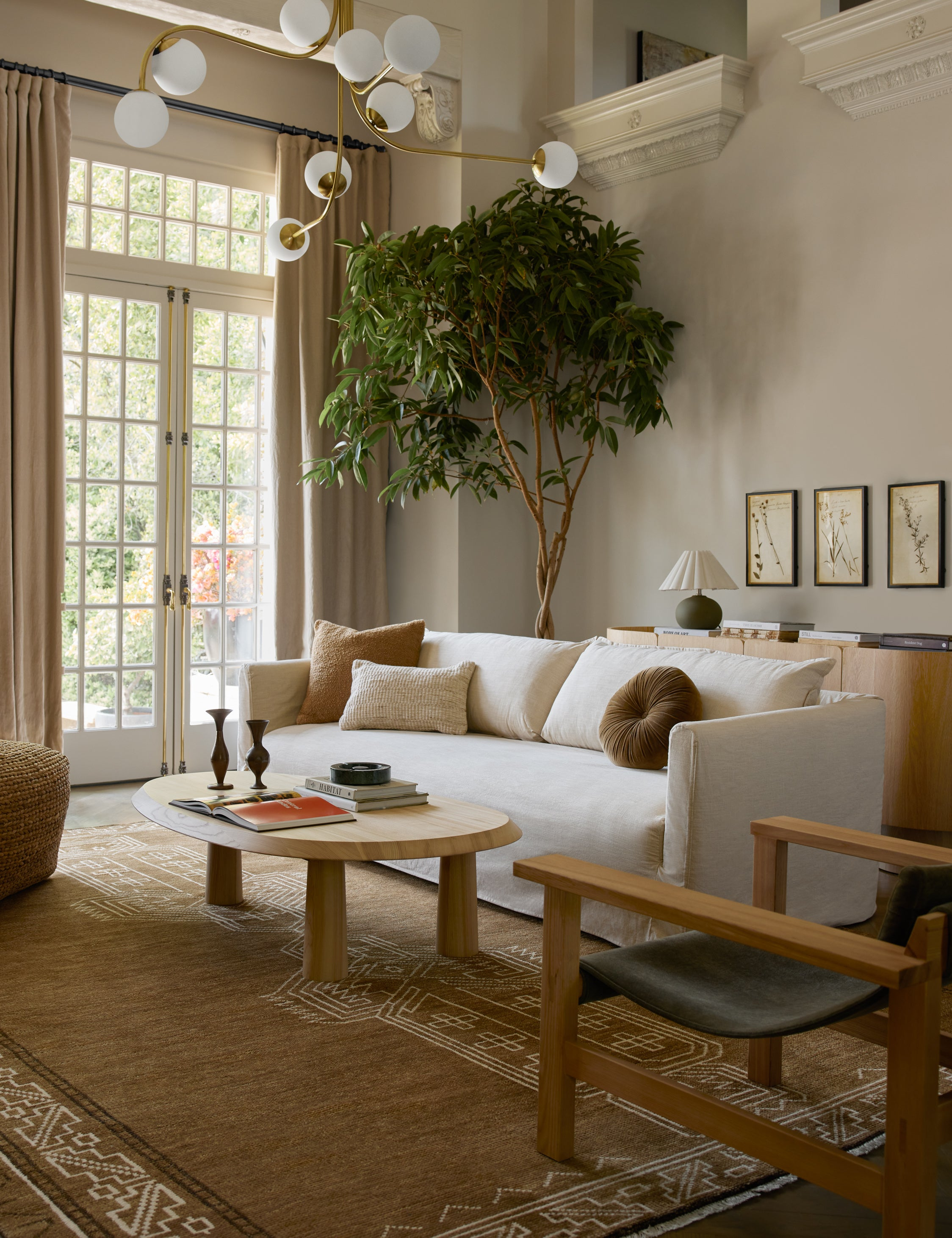 Lulu and Georgia white slipcover sofa in sunlit living room with wooden furniture