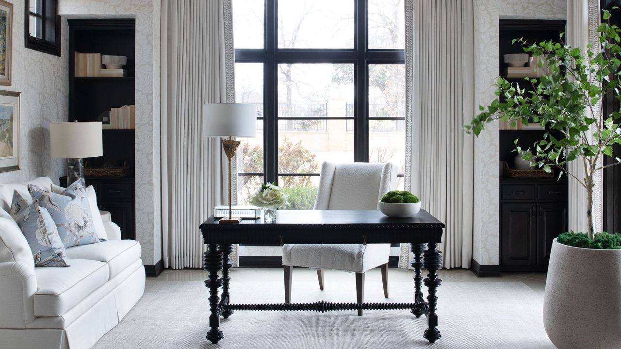 Study with black wooden desk and light colored wallpaper that matches the curtains