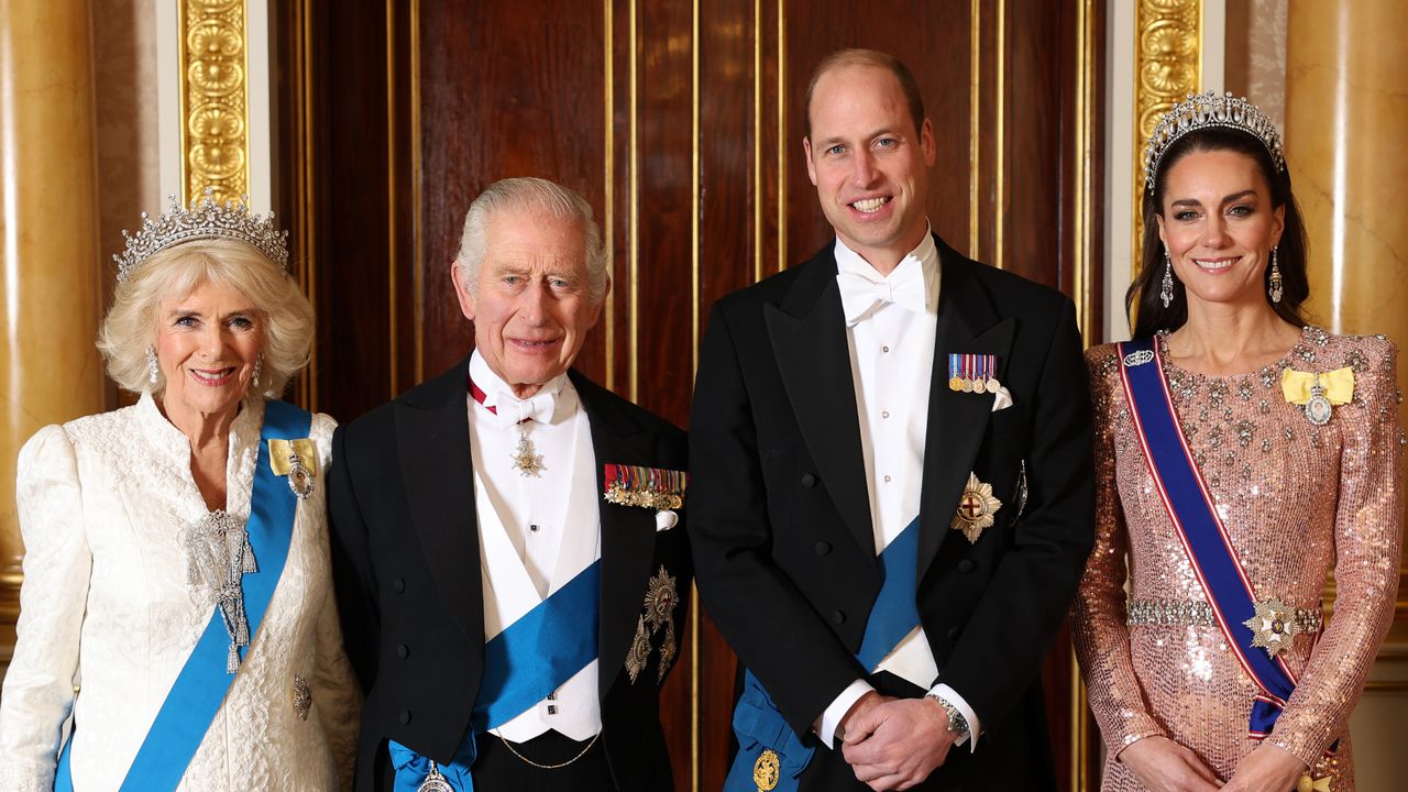 Queen Camilla and Princess Kate wearing evening gowns and tiaras standing next to King Charles and Prince William wearing tuxedos