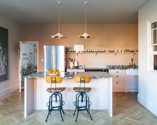 Modern pink kitchen with island and industrial stools
