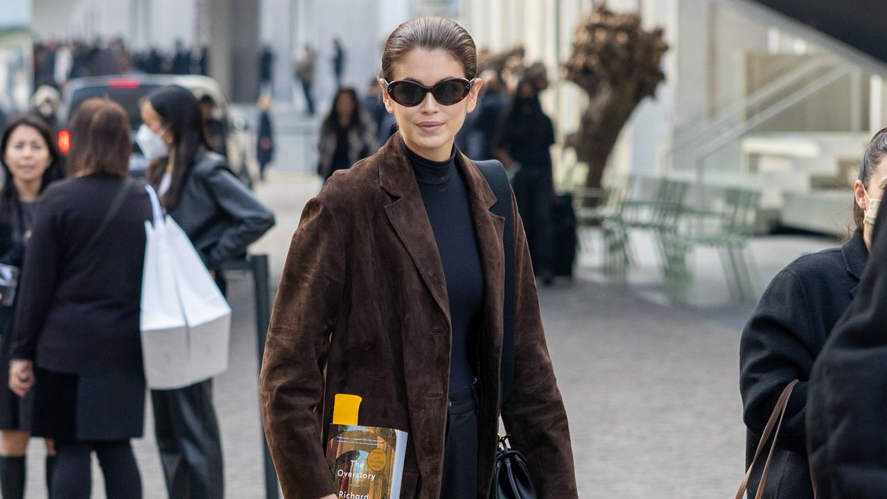 Kaia Gerber wearing brown suede coat with black mock neck top