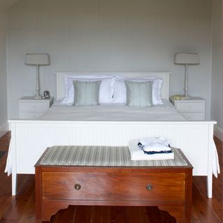 white bedroom with wooden floor and desk