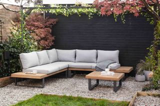 grey corner sofa set in front of black painted wall