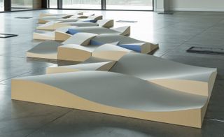Curved paper tiles that snake across the floor