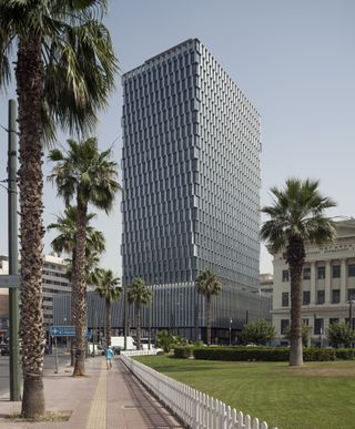 Piraeus Tower, a high rise in Athens with its renovation works completed by PILA, seen in hero glory, gleaming facade and slanted fin shading