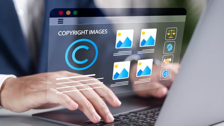 A person types on a laptop with "copyright images" on the screen