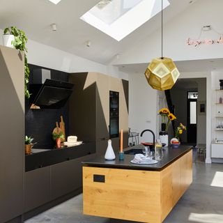 Extended kitchen with floating island pendant light and rooflights flooding the space with natural light