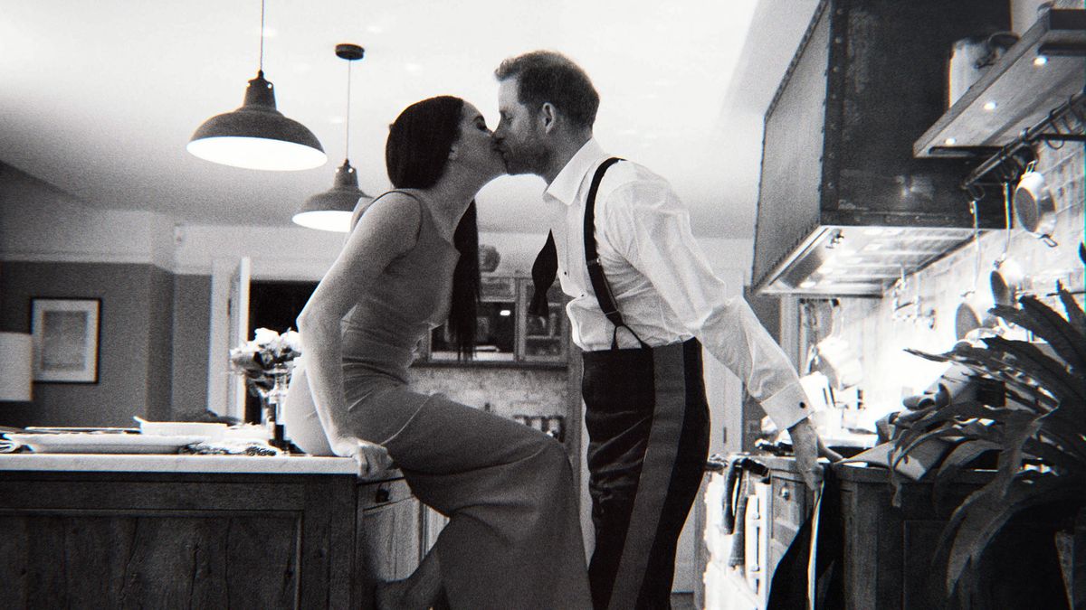 (L to R): Meghan Markle and Prince Harry kiss in the kitchen in an image from the Harry and Meghan docuseries