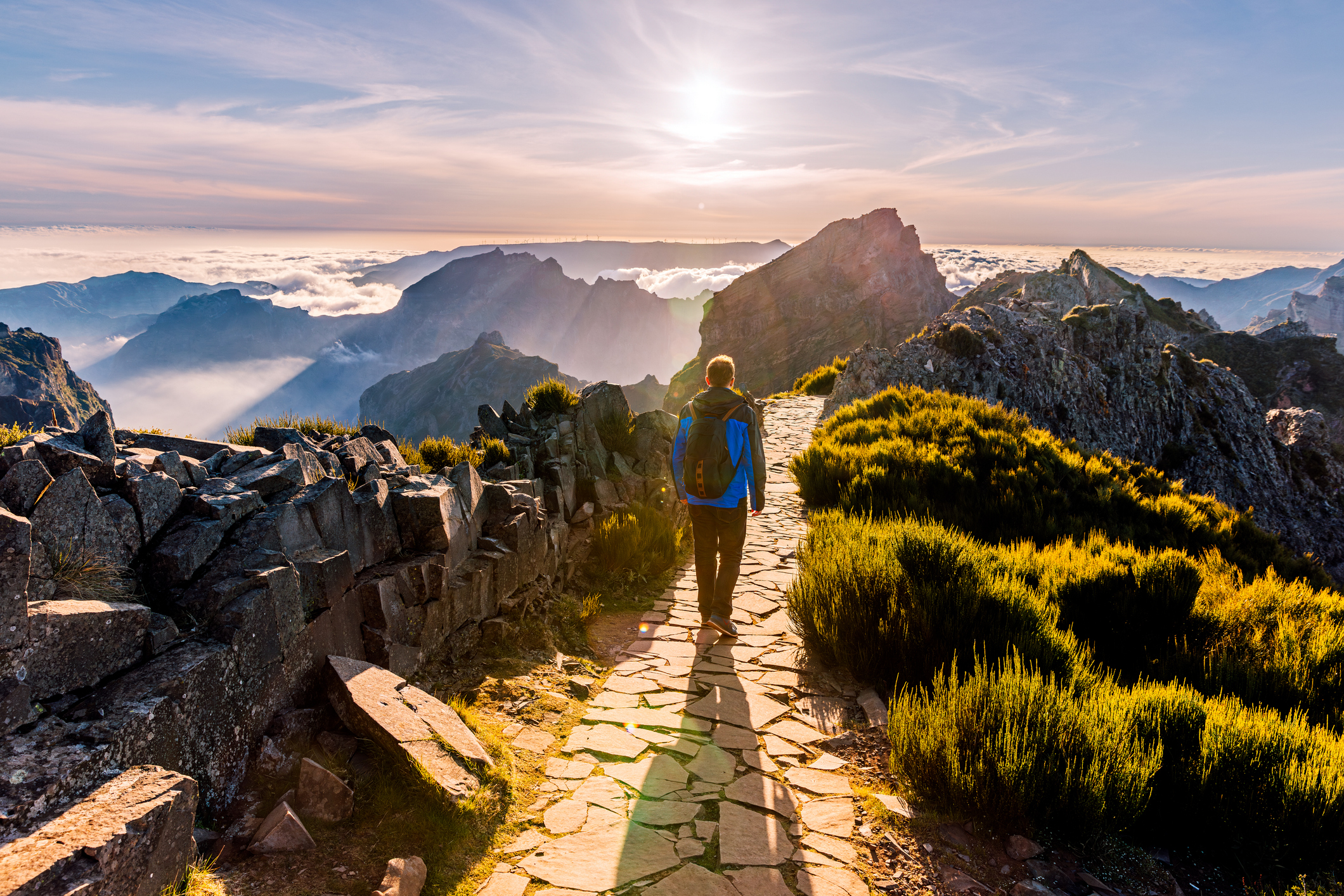 a hiker walking along a mountaintop path