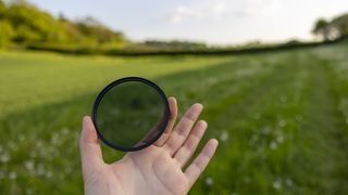 The Kenko Pro1D+ circular polarizing filter held in a woman's hands