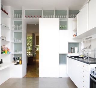The bookshelves also assume different functions depending on the location; in the kitchen they act as cabinets