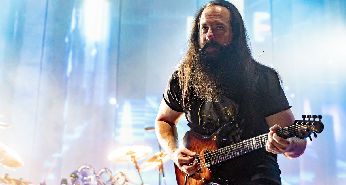 Against a backdrop of celestial stage lights, John Petrucci plays a riff on his signature Ernie Ball Music Man JP15 7-string