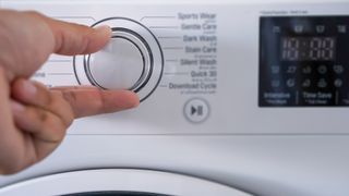 Person choosing washing machine cycle