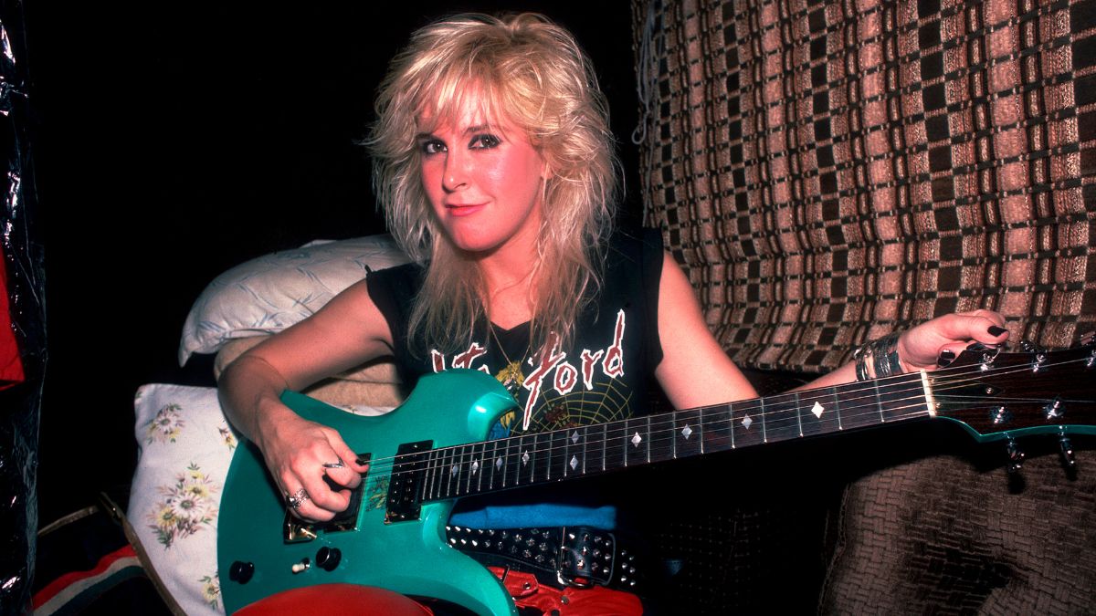 Portrait of American Rock musician Lita Ford as she poses with a guitar in her tour bus, Chicago, Illinois, September 30, 1984