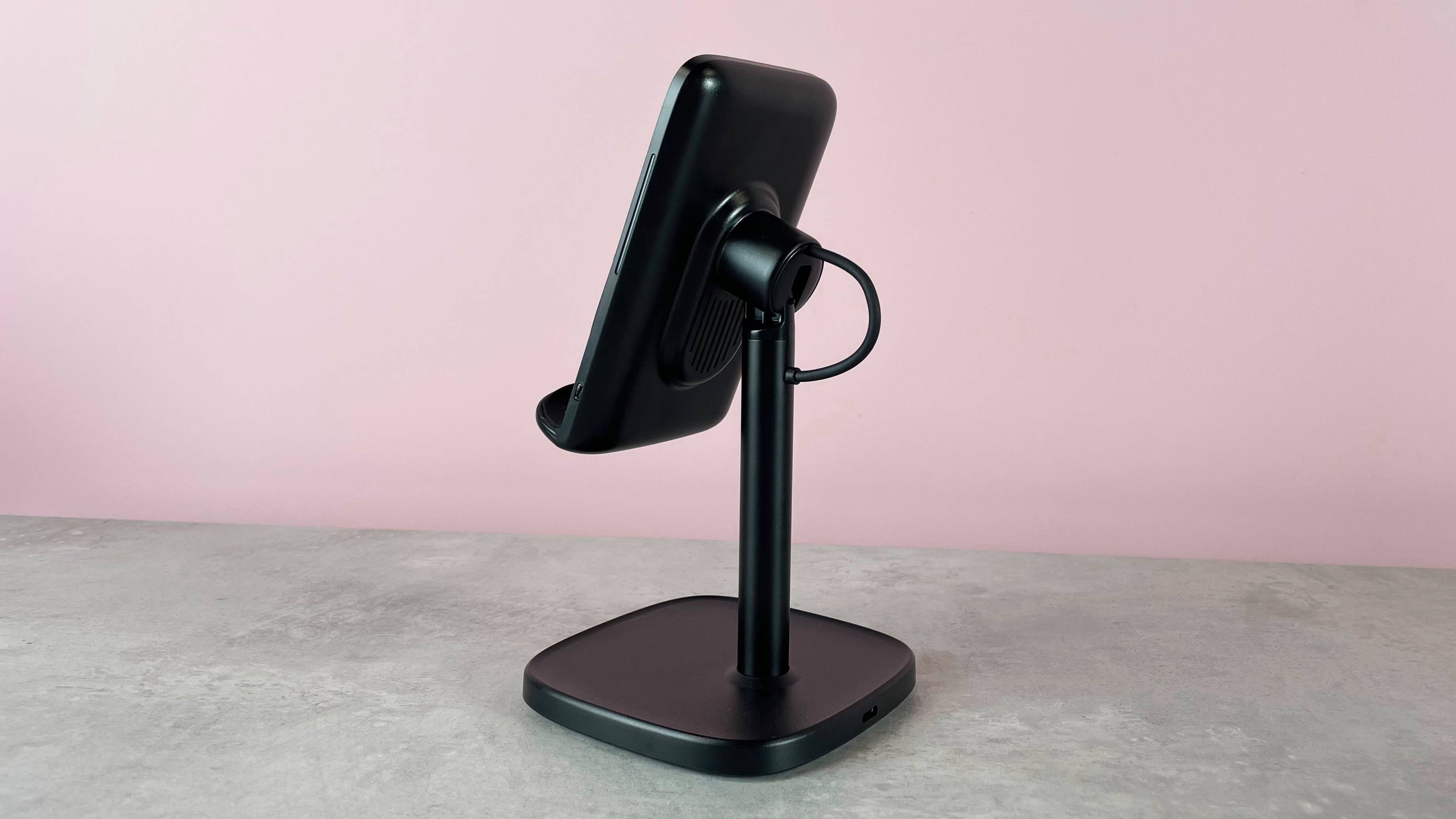 The back view of the INIU I212 Adjustable Wireless Charger which is pictured sitting on a grey stone surface against a pink background.
