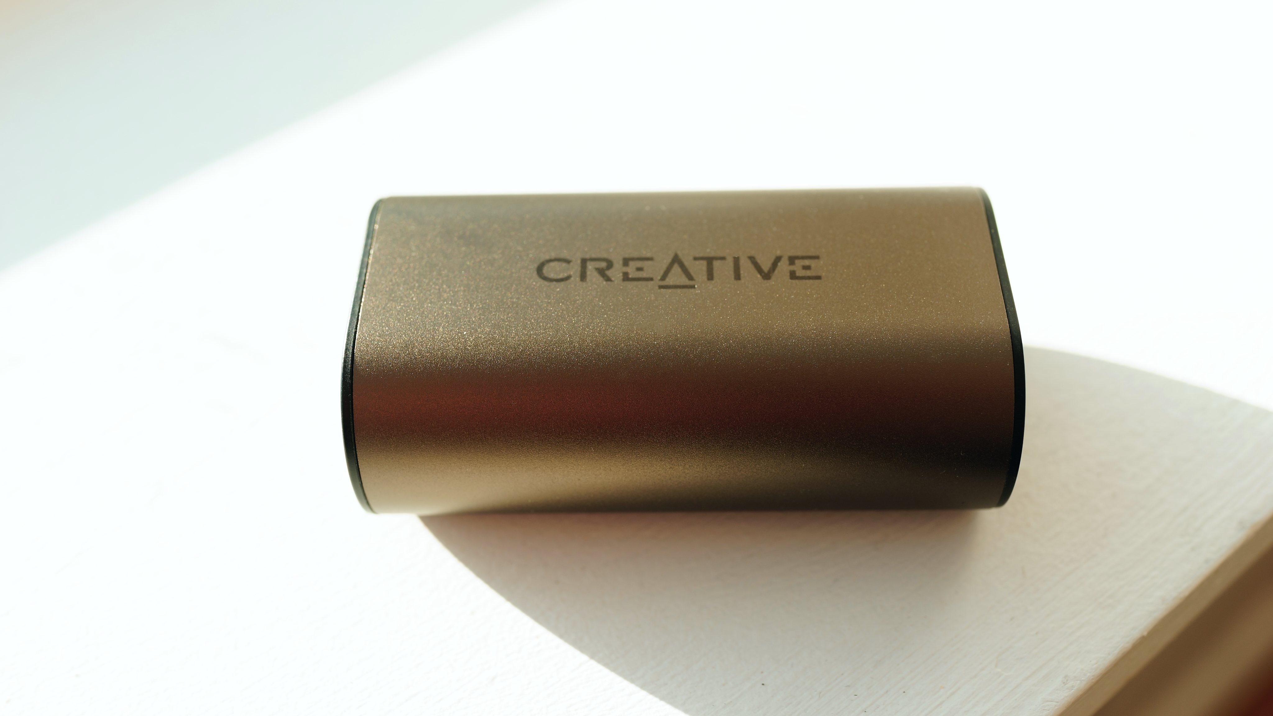 Creative Outlier Pro ligger i ladeetuiet i en solbeskinnet vindueskarm