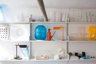 Pieces by ﻿BarberOsgerby displayed on 3 layers of a white floating shelf