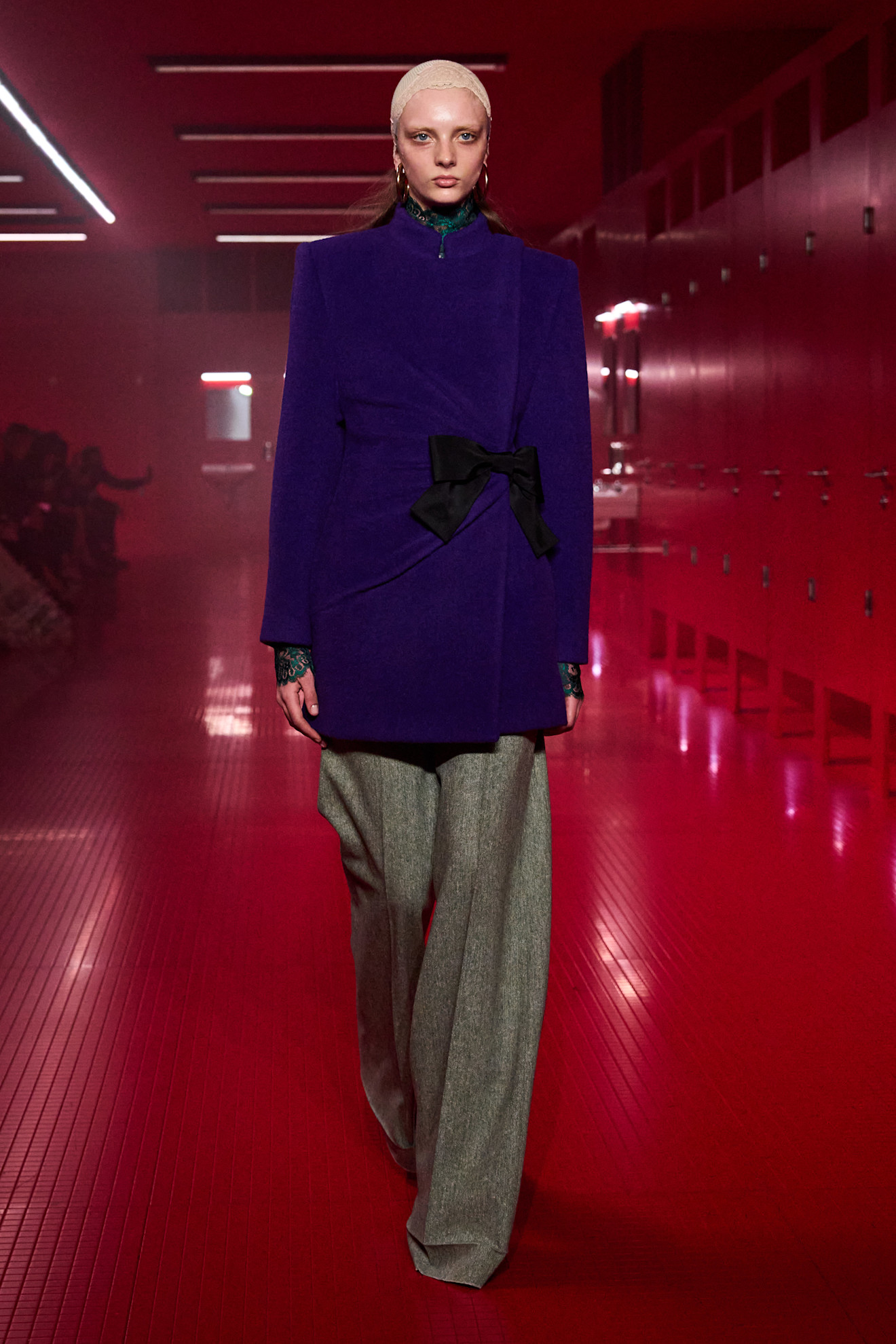 A Valentino model wearing a purple coat and gray pants