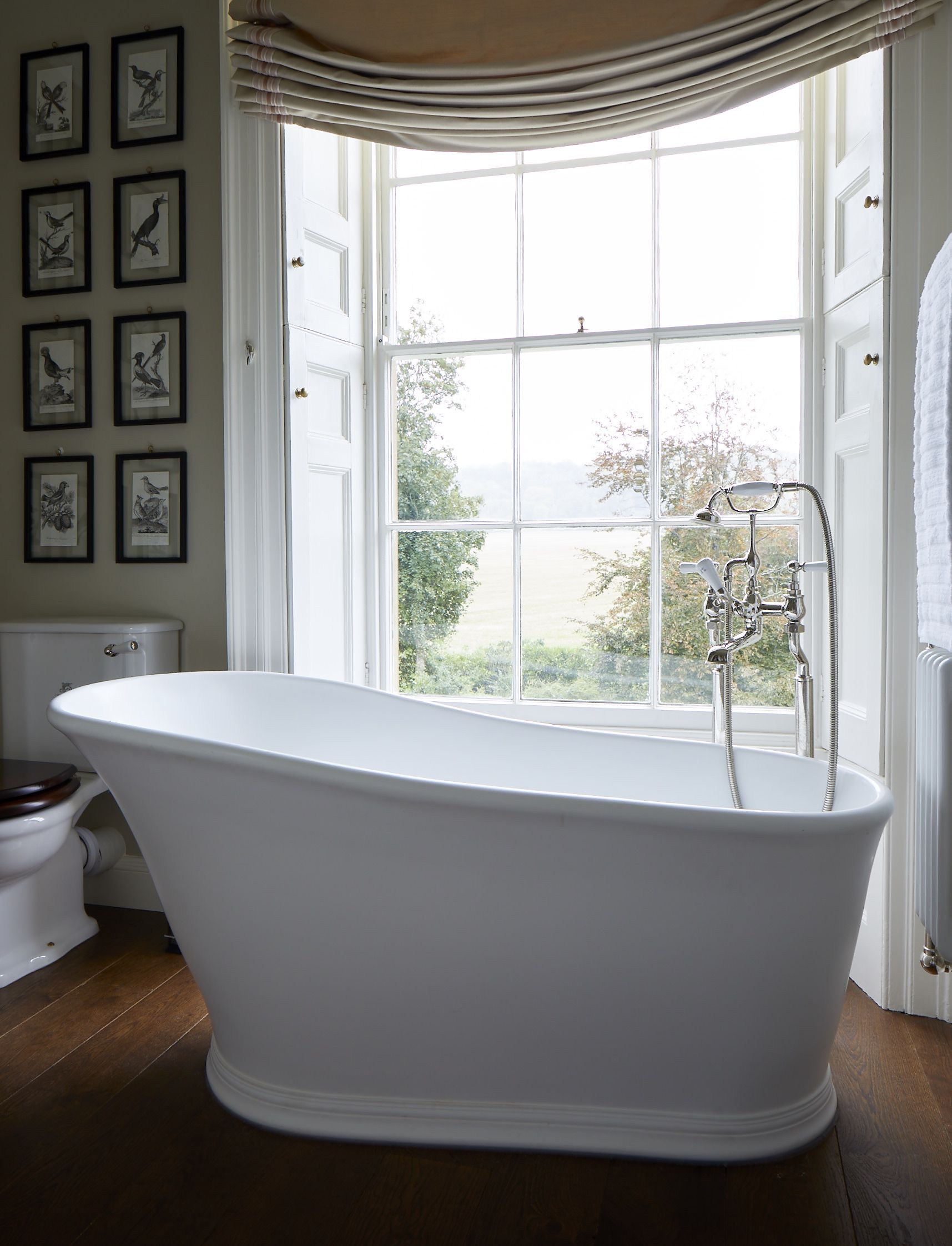 Dark wooden floor, white bath, white shutters