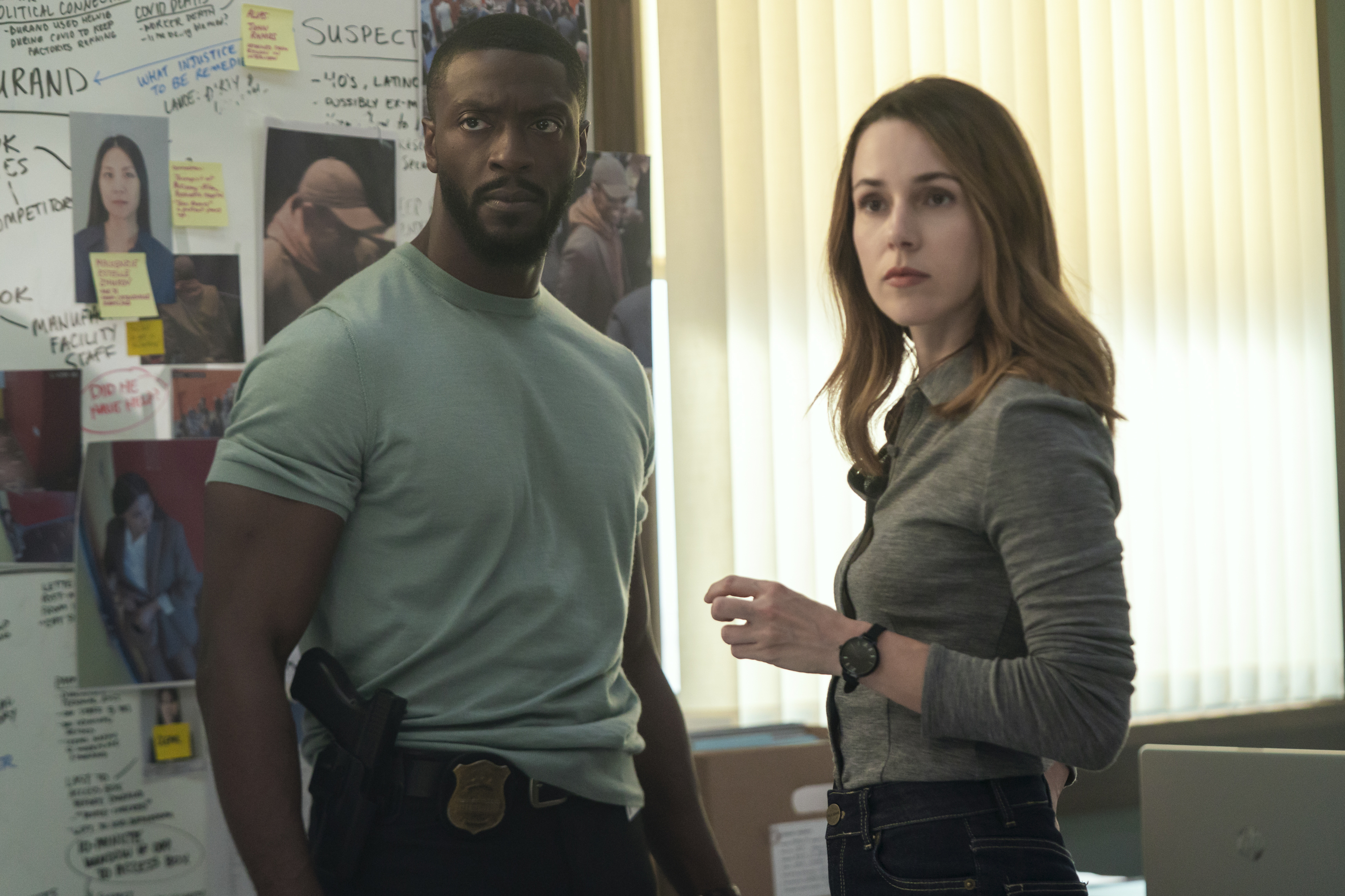 Alex Cross (Aldis Hodge) and Kayla Craig (Alona Tal) stand in front of a board full of photos and notes about a case they're on in cross season 2