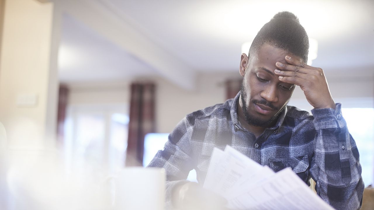 A man looks concerned as he looks over his car insurance bill.