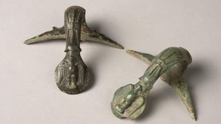 two green-tinged bronze handles