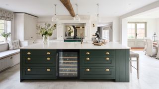 large open plan green kitchen with exposed beams