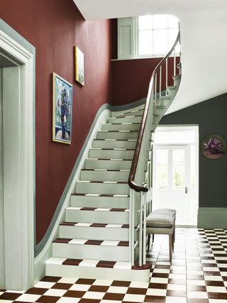 Brown and white tiled floor and stairs, red and green walls
