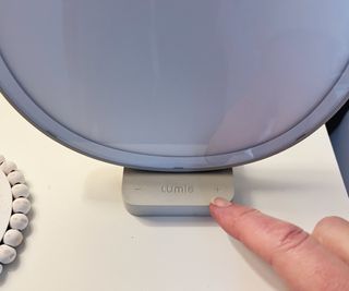 close up of lumie dash with finger pointing to dimmer control