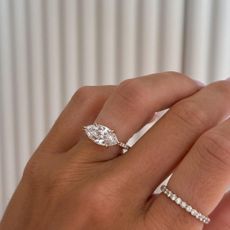 Woman wearing east-west set marquise engagement ring.