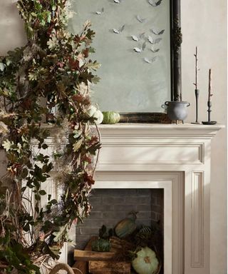 neutral fireplace mantel filled with pumpkins and fire wood with foliage