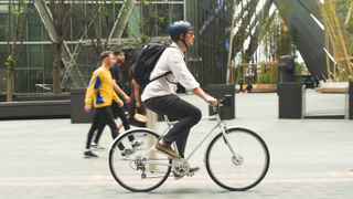 Man riding city bike using Swytch e-bike conversion kit