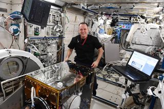 The RemoveDebris satellite, the largest ever deployed from the International Space Station, is moved into an airlock by NASA astronaut Ricky Arnold. It was deployed June 20, 2018.