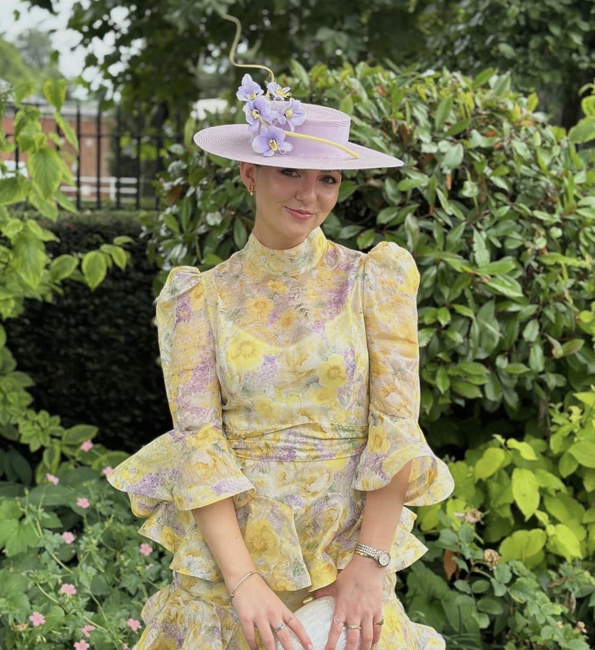 Lauren Price wearing a yellow dress and a purple hat