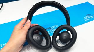 the jlab jbuds open headphones photographed with a white and blue background