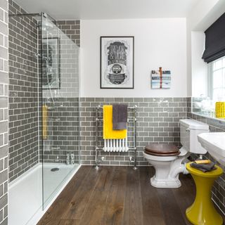 bathroom with grey tiles and wooden flooring