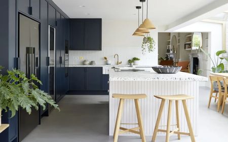 kitchen with white walls, white island, and dark blue cabinets