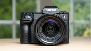 Fujifilm GFX100 II on a wooden table, front of camera