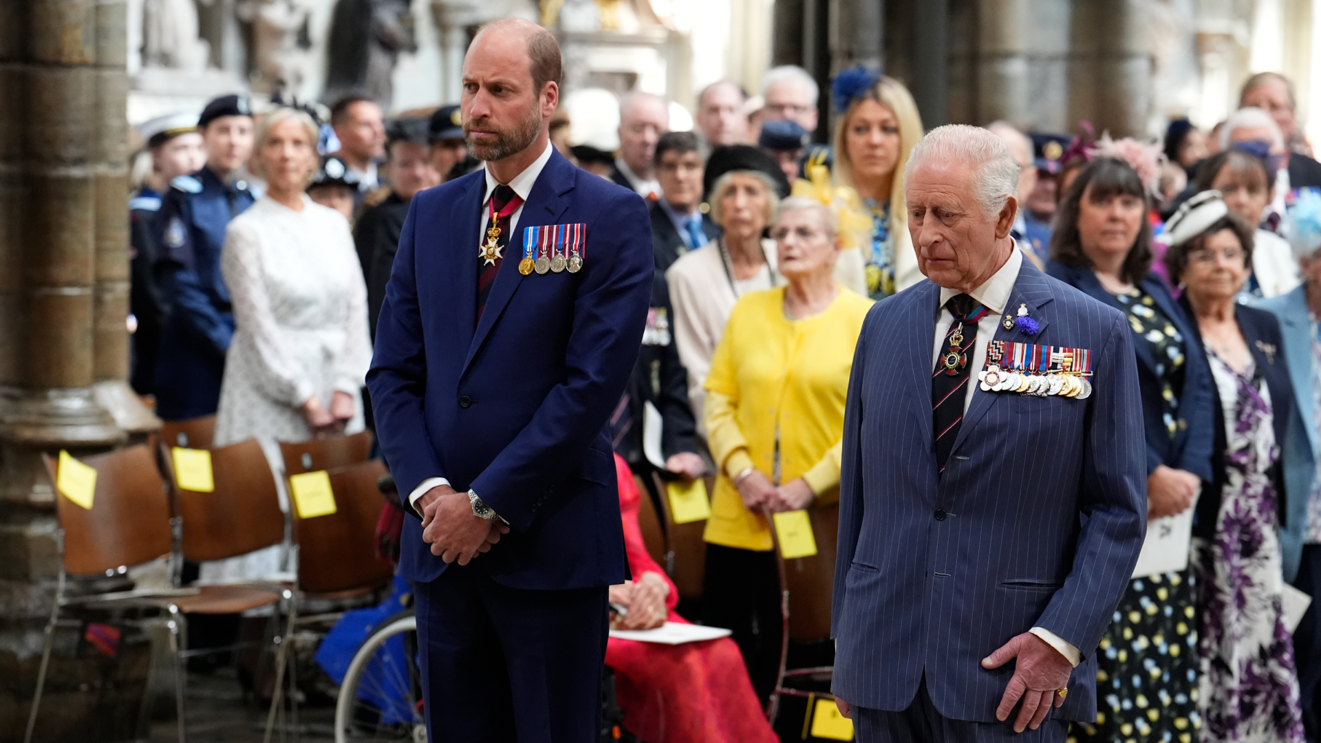 Prince William and King Charles wearing blue suits with medals standing next to each other
