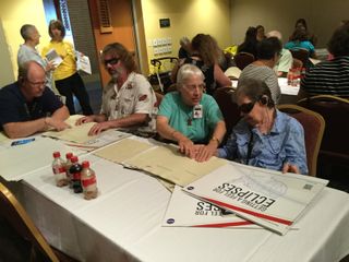 At their fingertips: Adult participants getting a feel for solar eclipses at a recent Vision Rehabilitation & Assistive Technology Expo.