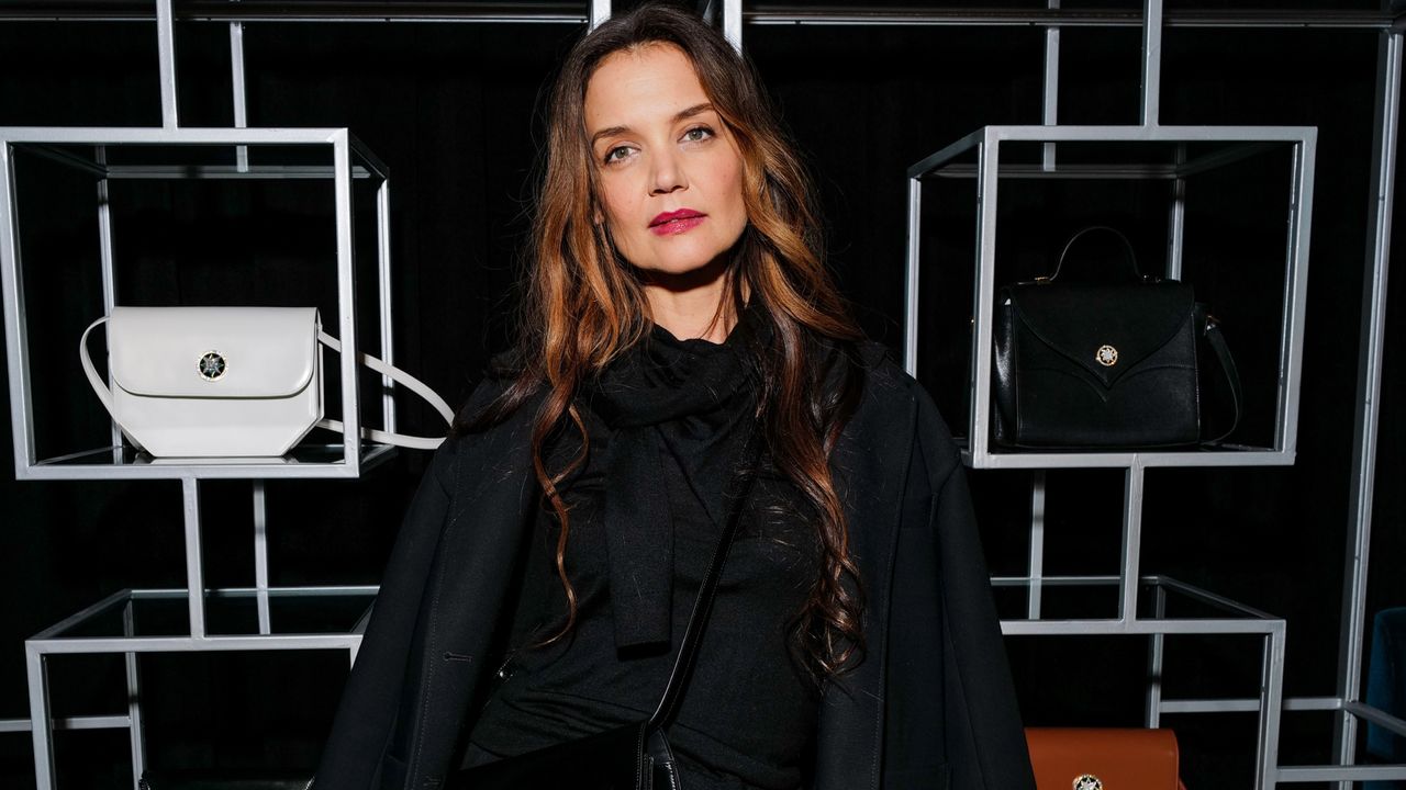 Katie Holmes attends the 11 Julliet launch party wearing a black coat with a bejeweled crossbody