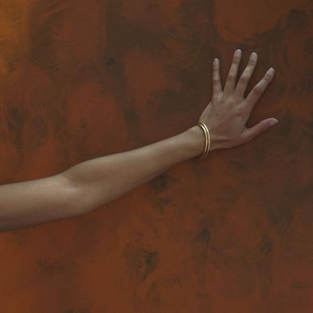 Flowers, a woman's torso and a hand against a wall