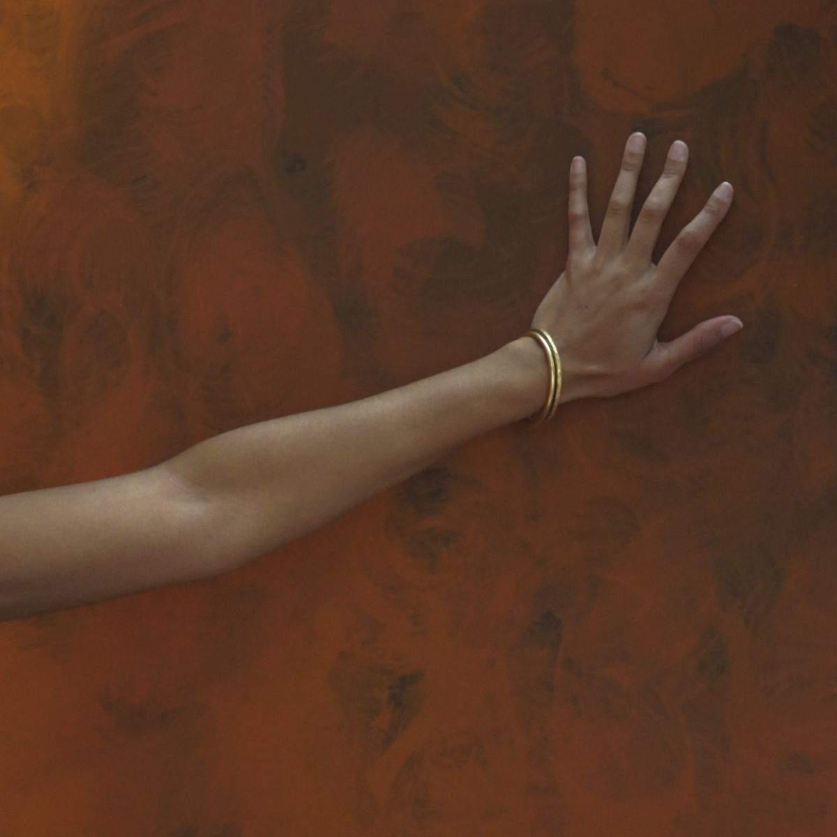 Flowers, a woman's torso and a hand against a wall