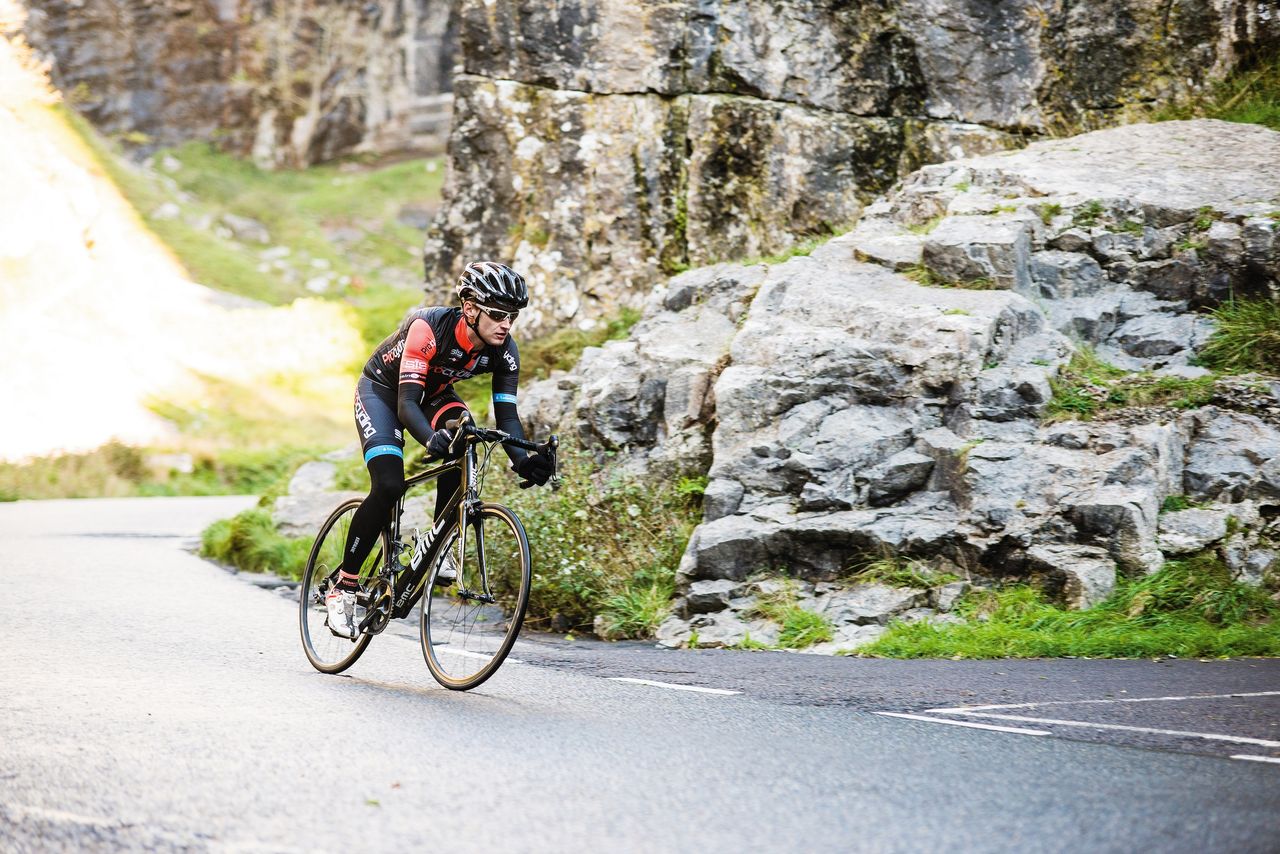 Cyclist riding through Cheddar Gorge, Somerset UK