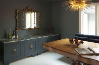 cozy dining room color drenched in a deep blue/green paint color