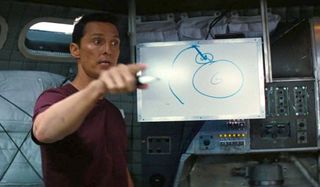 Interstellar Cooper discussing scientific theory with a white board